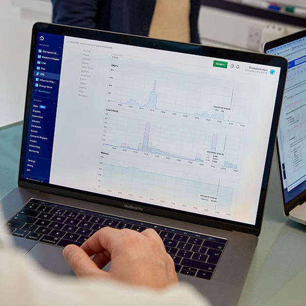Person viewing performance monitoring graphs on a laptop screen.